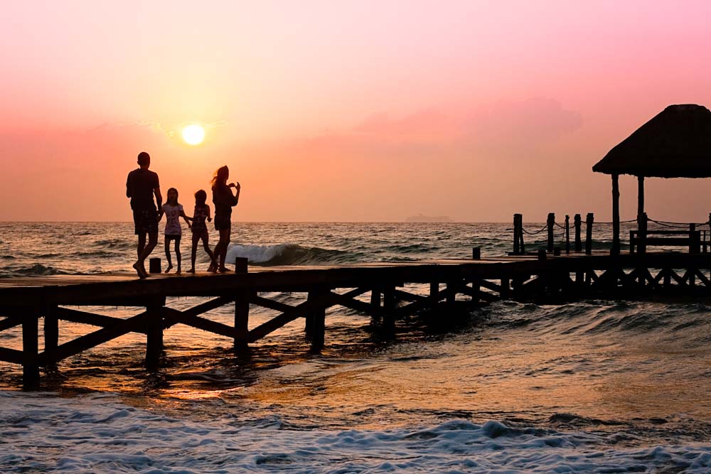 Family on pier at sunrise