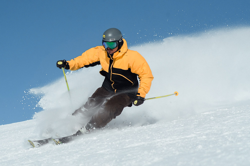 Man in yellow jacket skiing